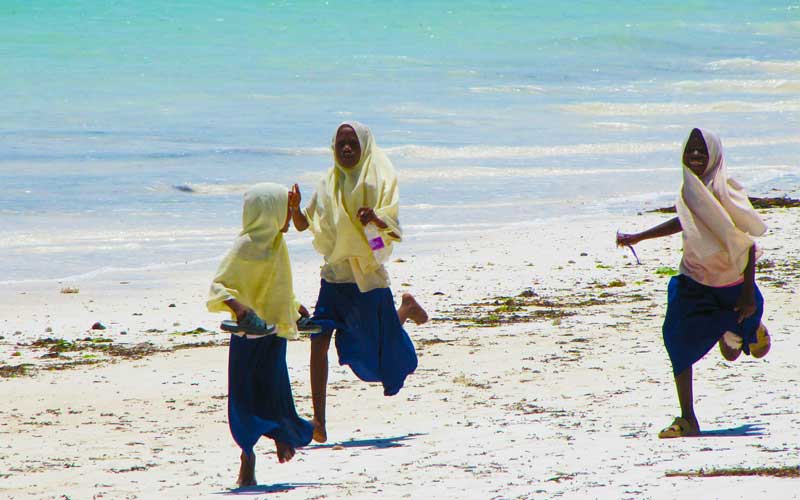 Muslim-girls-running-beach-Zanzibar
